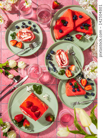 Delicious reddish pancakes and strawberry cake served on green plates for a fancy brunch 142504801