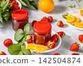 Homemade strawberry jam with orange slices and fresh strawberries 142504874