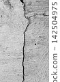 Deep vertical cracks in rough gray wall texture. 142504975