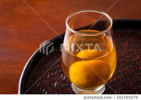 用玻璃杯喝梅子酒。 用玻璃杯喝梅子酒。 142505079