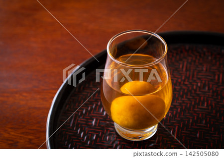 用玻璃杯喝梅子酒。 用玻璃杯喝梅子酒。 142505080