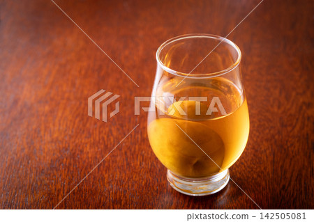用玻璃杯喝梅子酒。 142505081