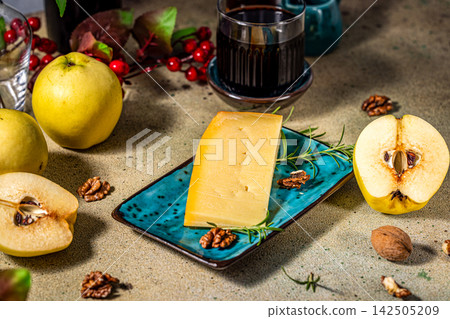 Wedge of cheese with quince and walnuts on serving platter Wedge of cheese with quince and walnuts on serving platter 142505209