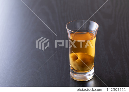 用玻璃杯喝梅子酒。 142505231