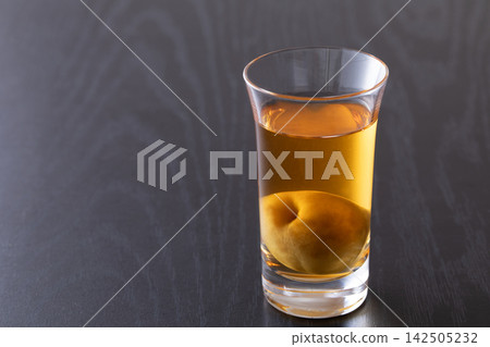 用玻璃杯喝梅子酒。 142505232