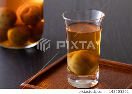 用玻璃杯喝梅子酒。 142505261