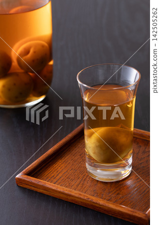 用玻璃杯喝梅子酒。 用玻璃杯喝梅子酒。 142505262