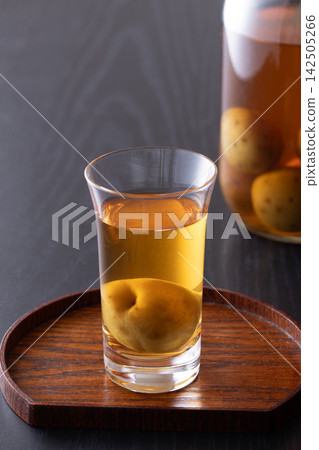 用玻璃杯喝梅子酒。 用玻璃杯喝梅子酒。 142505266