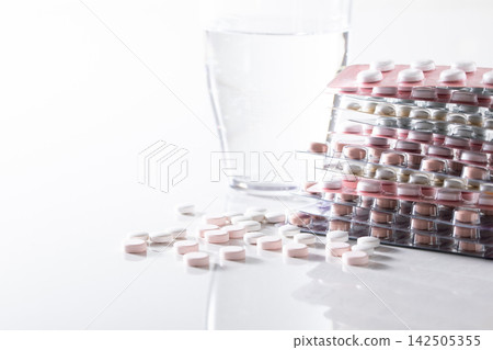 A glass of water and supplements and various medicines A glass of water and supplements and various medicines 142505355
