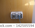 Dirty Electrical Wall Socket with Black Grime Dust and Stains Around Plug Showing Neglected Outlet and Poor Household Cleaning 142505594