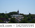 Historic Church Towers Rising Above Residential Houses and Green Trees in Kamianets Podilskyi Ukraine on Sunny Summer Day 142505595