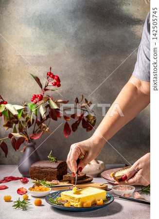 Chef spreading butter on bread with cloudberries and rosemary garnish Chef spreading butter on bread with cloudberries and rosemary garnish 142505745