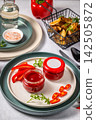 Two jars of red hot chili pepper sauce with blank label on a plate 142505872