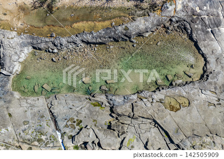 Aerial view of the rock pool at Angourie on the NSW North Coast, showcasing clear water surrounded by rugged rock formations and the distinctive natural coastal landscape of the Clarence Valley, Aerial view of the rock pool at Angourie on the NSW North Coast, showcasing clear water surrounded by rugged rock formations and the distinctive natural coastal landscape of the Clarence Valley, 142505909
