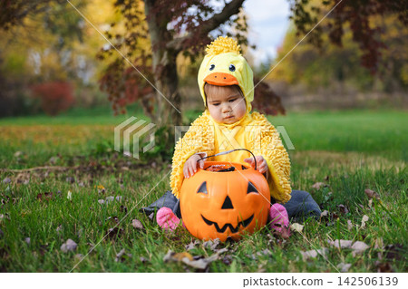 Toddler in Yellow Duck Costume With Jack-o-Lantern Bucket Toddler in Yellow Duck Costume With Jack-o-Lantern Bucket 142506139
