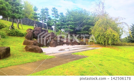 A Japanese garden featuring beautiful stone arrangements and rows of pine trees. A Japanese garden featuring beautiful stone arrangements and rows of pine trees. 142506178