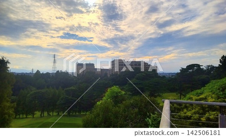 城市日落美景在鬱鬱蔥蔥的自然環境中徐徐展開。 城市日落美景在鬱鬱蔥蔥的自然環境中徐徐展開。 142506181