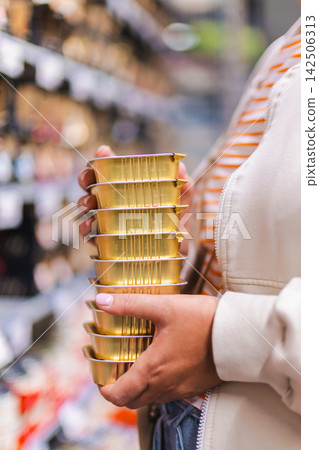 Woman Holding Stack of Gold Canned Pet Food Woman Holding Stack of Gold Canned Pet Food 142506313
