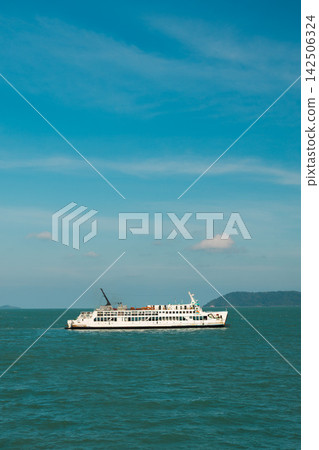 White Passenger Ferry Crossing Turquoise Sea Near Forested Island White Passenger Ferry Crossing Turquoise Sea Near Forested Island 142506324