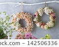 A natural, handmade wreath adorned with dried flowers and ribbons. 142506336