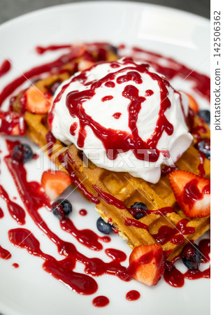 Garnished dessert. Breakfast served. Crispy baked wafer with ice cream red jam sauce drops. Delicious restaurant food with fresh berry. 142506362