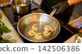 Cooking shrimp. Frying meal. Chef hand roasting peeled food on hot oil metal pan on stovetop. Professional restaurant kitchen workflow. 142506386