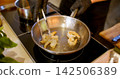 Preparing prawn. Seafood recipe. Chef gloved hand flipping peeled spicy ingredient on iron grill oil pan. Tasty nutritious delicious dish. 142506389