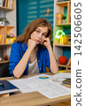Young woman on home table feeling tired and upset after failed work day leaning on hand indoors sad 142506605