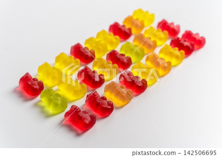 Rows of gummy bear candies arranged on a white surface Rows of gummy bear candies arranged on a white surface 142506695