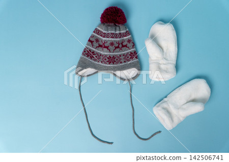 Warm hat and mittens on light blue background for winter season Warm hat and mittens on light blue background for winter season 142506741