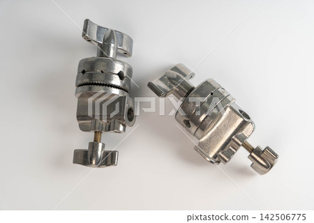 Metal clips and brackets for photography equipment on a white surface Metal clips and brackets for photography equipment on a white surface 142506775