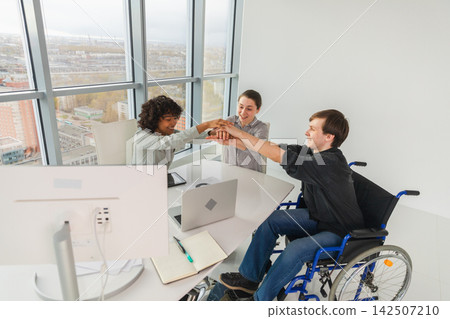 Stack of hands. Business startup teamwork unity concept. Top view of diverse multiracial business people putting hands together. Business colleagues during work process rejoice in success of company Stack of hands. Business startup teamwork unity concept. Top view of diverse multiracial business people putting hands together. Business colleagues during work process rejoice in success of company 142507210