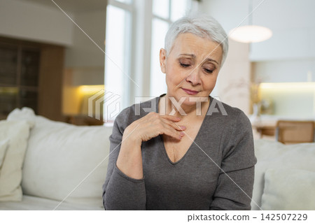 Sad tired ill sick lonely disappointed older senior woman sitting at home alone. Unhappy mature grandmother experiencing grief relative death bad news. Stressed elder lady suffering from loneliness Sad tired ill sick lonely disappointed older senior woman sitting at home alone. Unhappy mature grandmother experiencing grief relative death bad news. Stressed elder lady suffering from loneliness 142507229