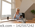 Confident middle aged senior woman euphoric winner with smartphone. Older mature lady looking at cell phone reading great news getting good result winning online bid feeling amazed. Winning gesture 142507242