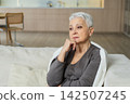 Sad tired ill sick lonely disappointed older senior woman sitting at home alone. Unhappy mature grandmother experiencing grief relative death bad news. Stressed elder lady suffering from loneliness 142507245