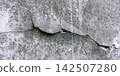 Cracked and Textured Grey Concrete Wall Surface 142507280