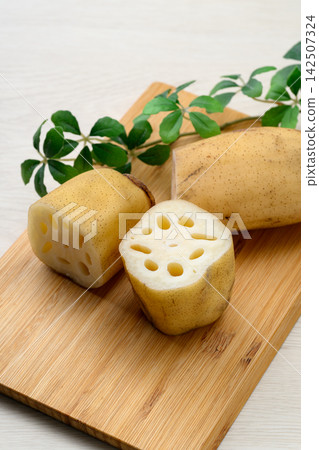 Fresh lotus root placed on a bamboo cutting board Fresh lotus root placed on a bamboo cutting board 142507324