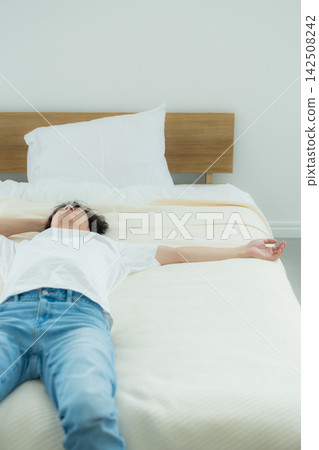 A man who is feeling down in the bedroom A man who is feeling down in the bedroom 142508242