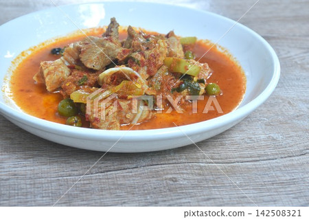 spicy fried pork cartilage with curry and eggplant on plate spicy fried pork cartilage with curry and eggplant on plate 142508321