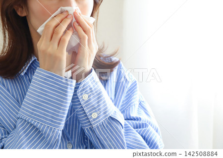 Woman blowing her nose; hay fever, rhinitis Woman blowing her nose; hay fever, rhinitis 142508884