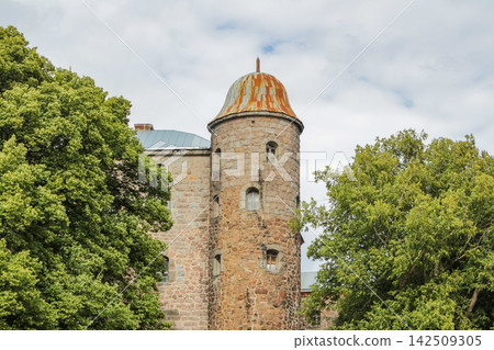 A rusty-domed stone tower nestled among trees in an open-air setting showcases historic architecture and the natural environment A rusty-domed stone tower nestled among trees in an open-air setting showcases historic architecture and the natural environment 142509305
