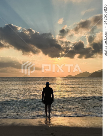 Silhouette of person standing on beach Silhouette of person standing on beach 142509820