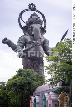 Large standing Lord Ganesha bronze sculpture against blue sky, famous landmark in Chachoengsao, Thailand Large standing Lord Ganesha bronze sculpture against blue sky, famous landmark in Chachoengsao, Thailand 142509972