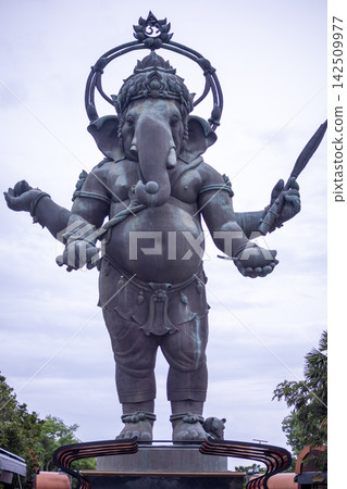 Large standing Lord Ganesha bronze sculpture against blue sky, famous landmark in Chachoengsao, Thailand 142509977