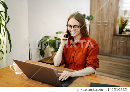 Young woman multitasking working from home office 142510285