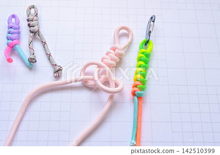 Hands making a keychain with paracord Hands making a keychain with paracord 142510399