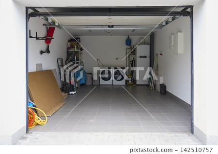 Open home garage with washing machine, dryer, shelves, tools and household equipment Open home garage with washing machine, dryer, shelves, tools and household equipment 142510757