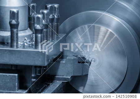 Close up of a lathe machine face cutting a metal part in a blue tone scene Close up of a lathe machine face cutting a metal part in a blue tone scene 142510908