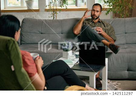 Man touching temple while discussing anxiety with psychologist Man touching temple while discussing anxiety with psychologist 142511297