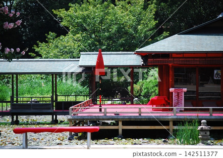 A garden scene featuring Japanese-style architecture and a red umbrella. A garden scene featuring Japanese-style architecture and a red umbrella. 142511377